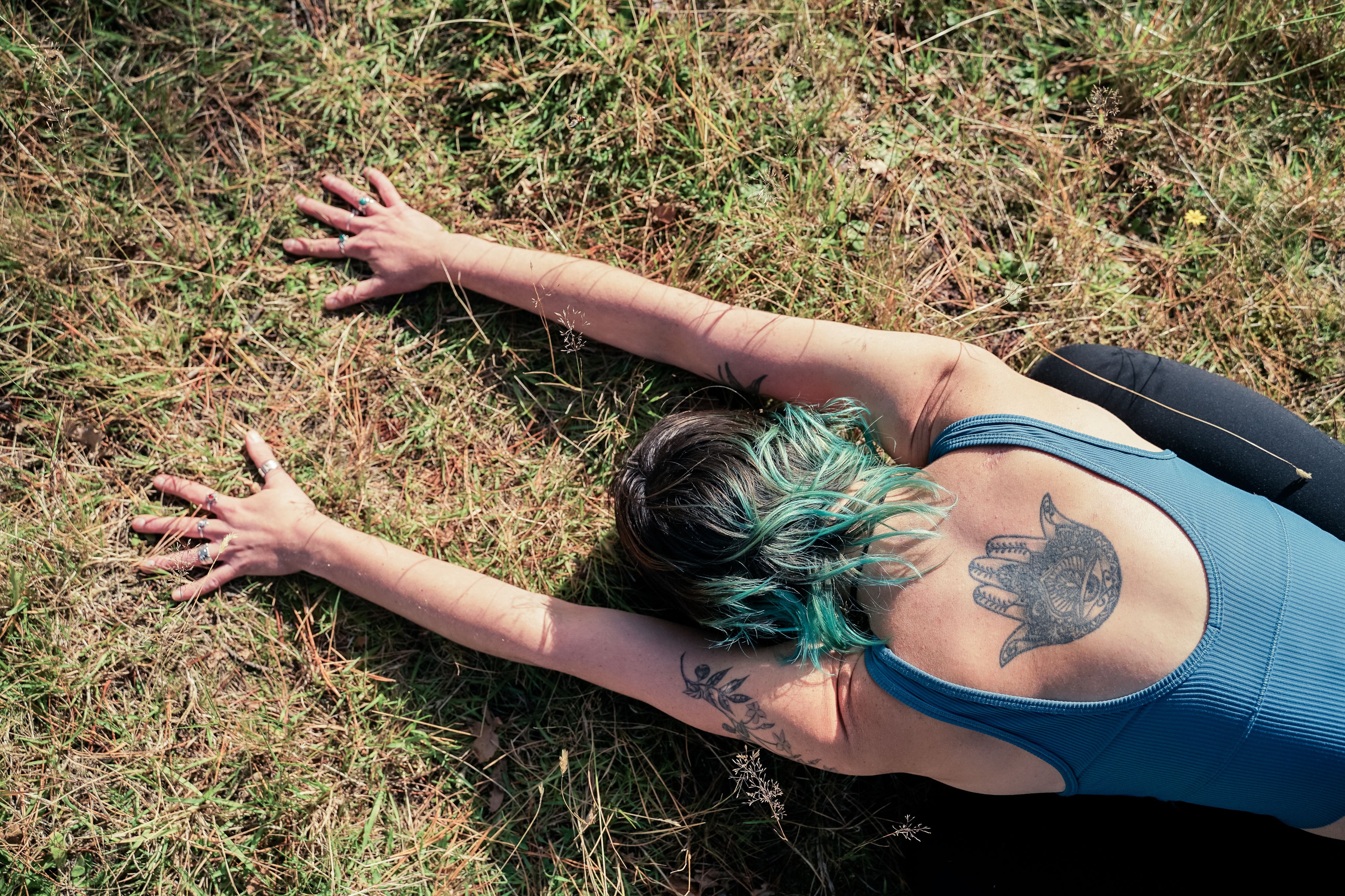 Becca on grass in child's pose, seen from above.