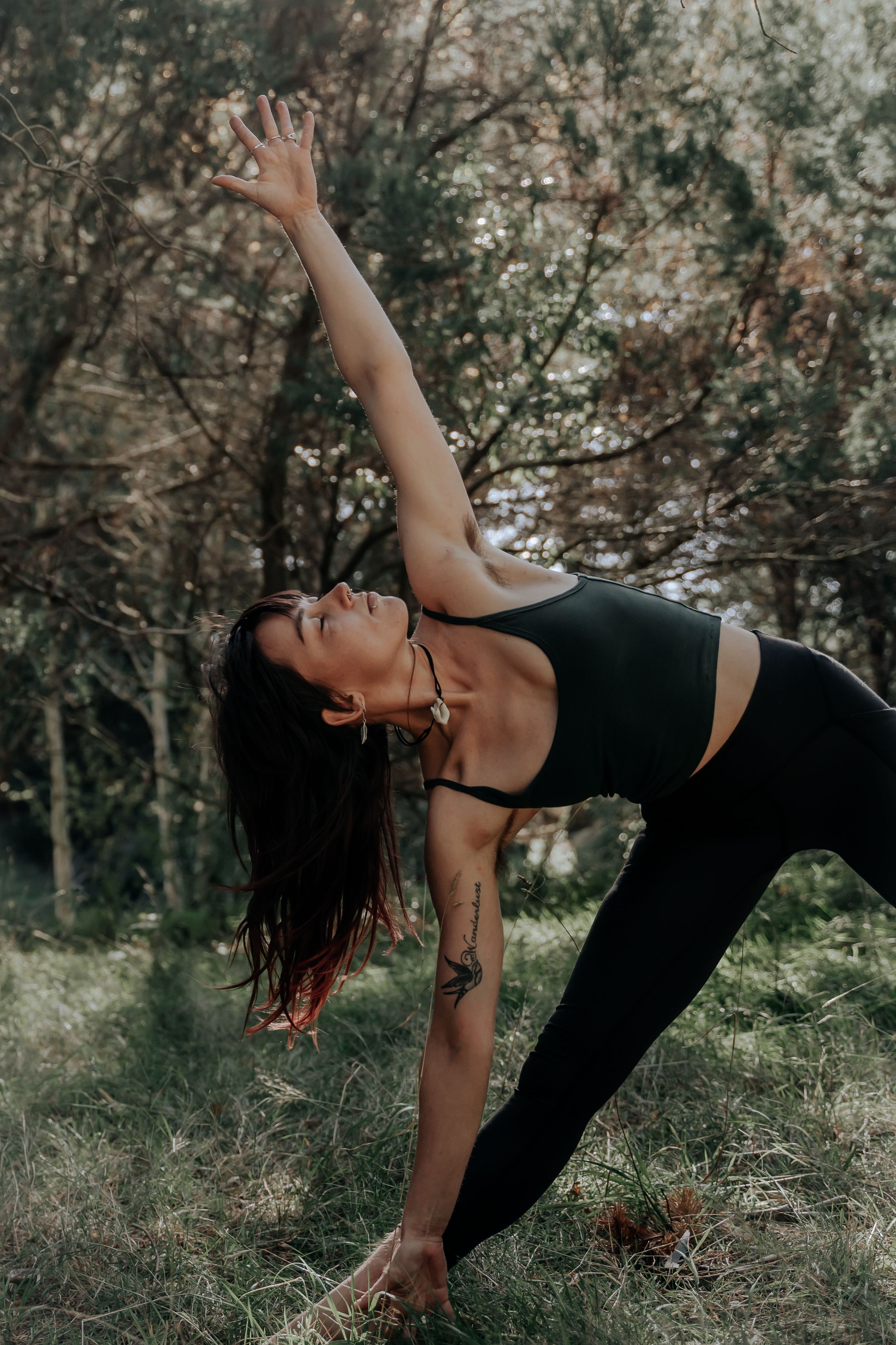 Becca standing bent over in a yoga pose, reaching towards the sky with one arm.